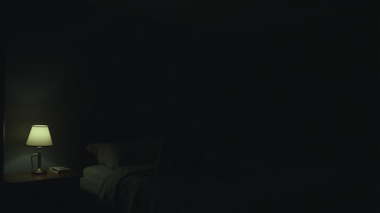 Tinnitus in a quiet bedroom Dark bedroom at night with a bedside lamp on and the bed unmade